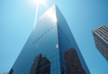 Gratte-ciel moderne avec logo bancaire en reflet urbain